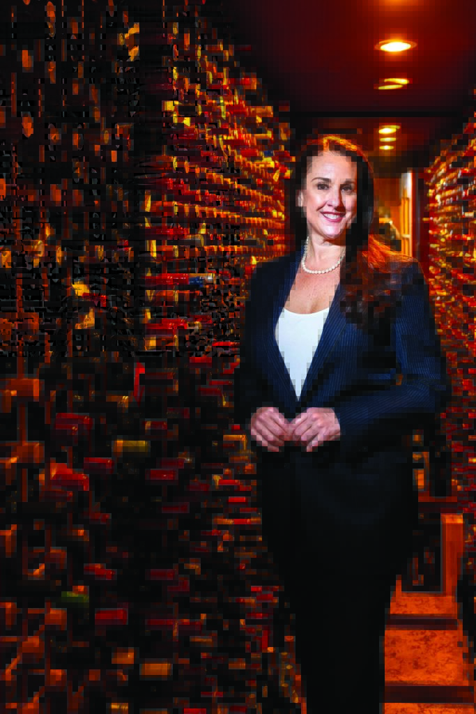 Wine Director Lindsey Fern in front of several wine bottles.
