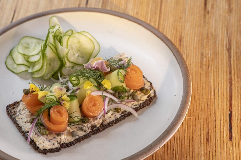 smørrebrød with gravlax, fresh herbs, red onion, capers, cucumbers, and everything-spiced crème fraîche. Photography by Brett Winter Lemon