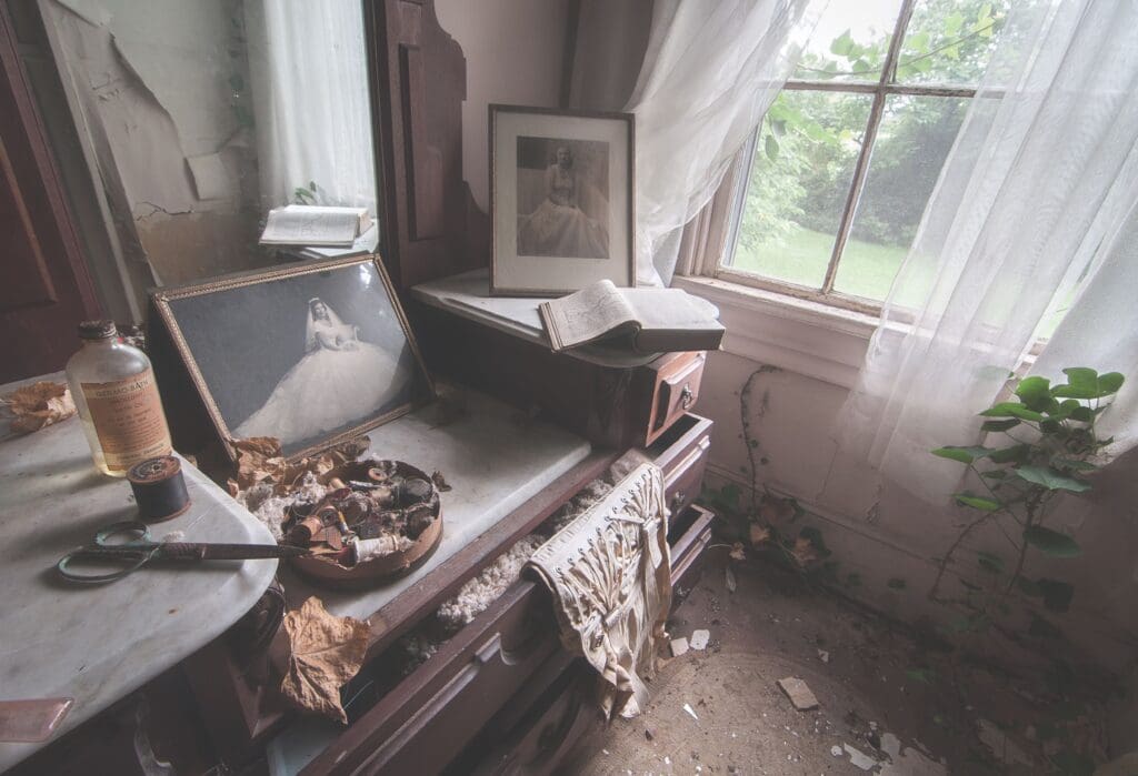 Vanity with photograph, sewing supplies and other quotidian items.