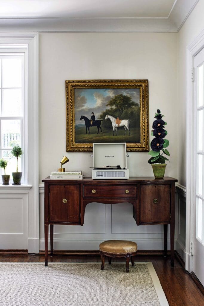 Sideboard with painting and record player with more interior design features.